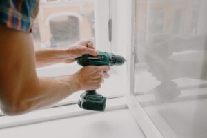 a man fixing a section of his house to engure property maintenance